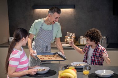 Pasta çarşafı olan adam neşeli çocuğun yanında.