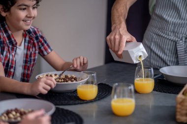 Erkeklere bakan çocuk meyve suyu döken