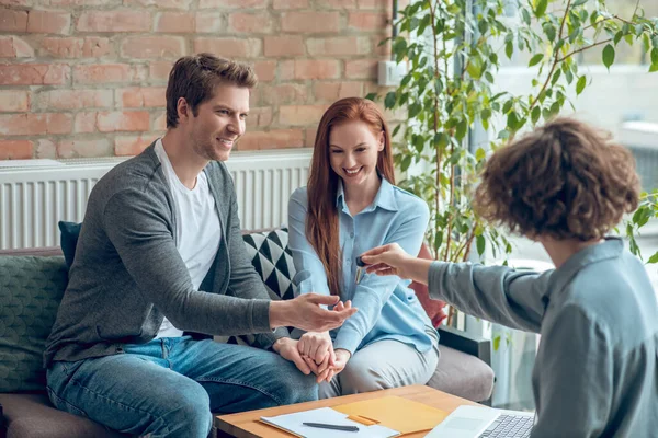 Kameraya geri dönen kadın adama anahtar veriyor.
