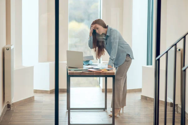 Nő áll fölé hajolva íróasztal az irodában — Stock Fotó