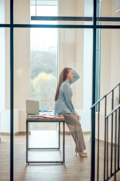 Pensando mulher inclinada na mesa no escritório — Fotografia de Stock