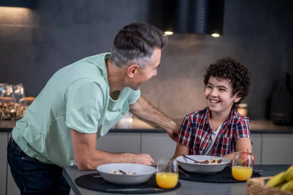 Joyful man and boy looking at each other — Stock Photo, Image