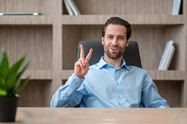 Een manager in een blauw shirt die zich vrolijk en gelukkig voelt — Stockfoto