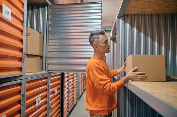 Empleado de almacén concentrado que coloca mercancías en contenedores de almacenamiento — Foto de Stock