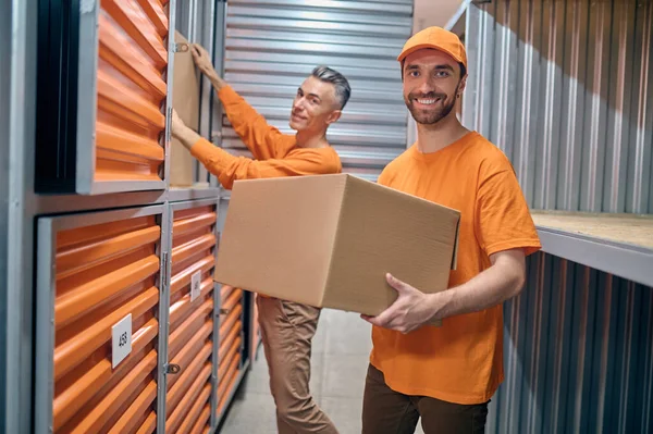 Cheerful loaders arranging goods in the warehouse — Stock Photo, Image