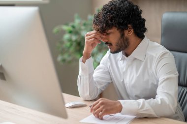 Genç Hintli işadamı yorgun görünüyor.