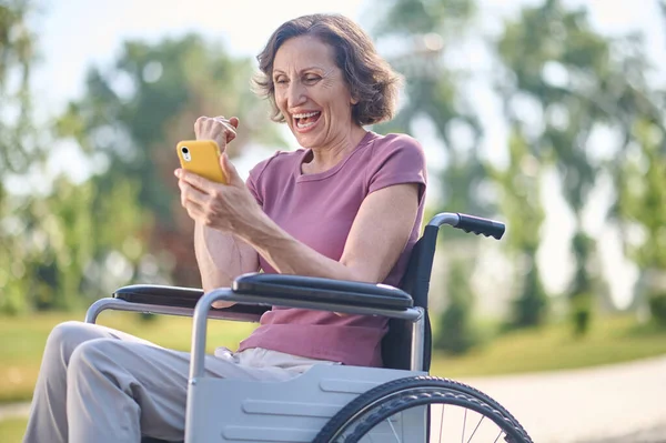 Tekerlekli sandalyede heyecanlı ve mutlu görünen bir kadın. — Stok fotoğraf