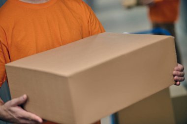 Erkek yükleyici depoya kutuları boşaltıyor.