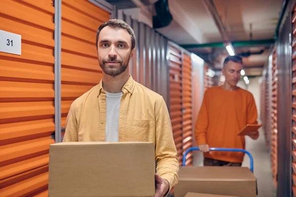 Two men unloading goods in the warehouse — Stock Photo, Image