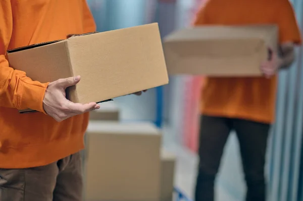 Male workers unloading goods in the warehouse — Stock Photo, Image