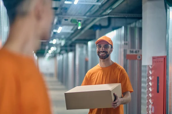 Cargador alegre trabajando con su colega en el área de almacenamiento — Foto de Stock