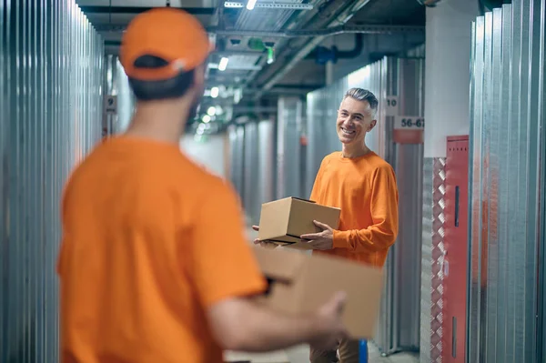 Smiling loader working with his coworker in the warehouse — Stock Photo, Image