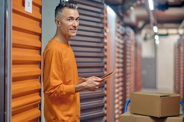 Radostný zaměstnanec skladu středního věku mezi nákladními kontejnery — Stock fotografie