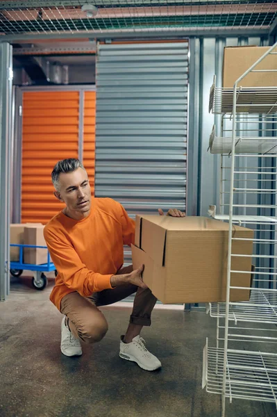 Сотрудник концентрированного склада кладет коробочные товары на полки — стоковое фото