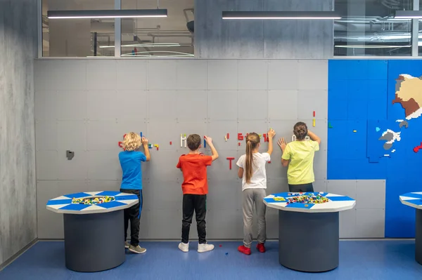Παιδιά με πλάτη στην κάμερα κάνουν ψηφιδωτά στον τοίχο — Φωτογραφία Αρχείου