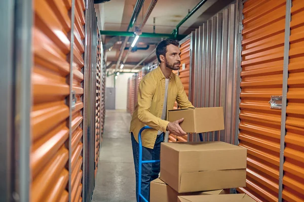 Concentrated male worker unloading items in the storehouse — Stock Photo, Image