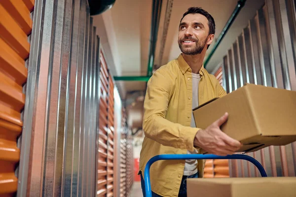 Joyful worker unloading items in the warehouse — Stock Photo, Image