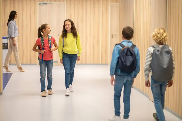Girls walking hallway and boys with backs to camera — Stock Photo, Image