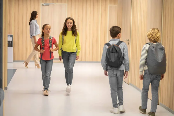 Chicas mirando a chicos caminando hacia ellos — Foto de Stock