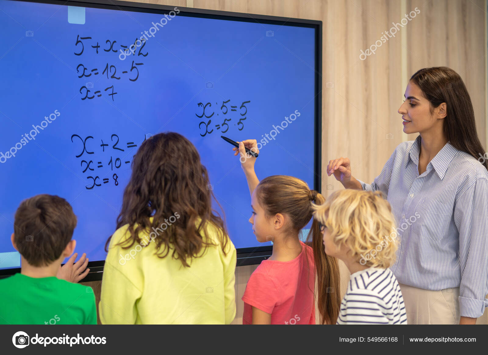 Enfants écrivant sur tableau noir et enseignant attentif regardant image  libre de droit par Dmyrto_Z © #549566168
