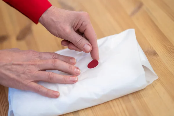 Mani toccando pacchetto di chiusura con adesivo — Foto Stock