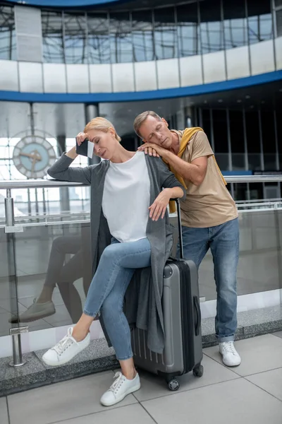 Biletli kadın ve erkek terminalde bekliyorlar.