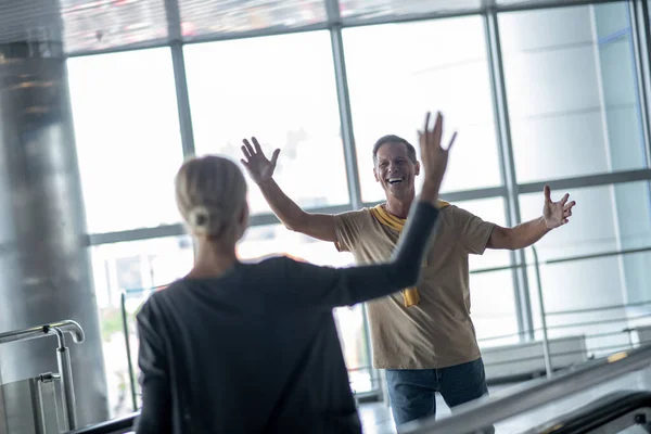 Hombre levantando la mano hacia la mujer en terminal — Foto de Stock