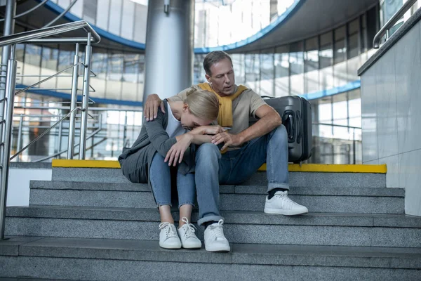 Mujer y hombre sentados en las escaleras en la terminal — Foto de Stock