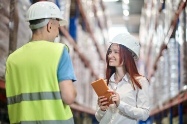 Kadın ve erkek depoda iletişim kuruyor.