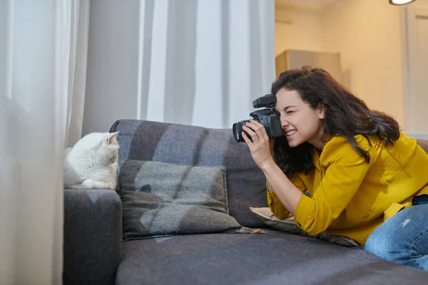 Młoda kobieta fotograf robi zdjęcia i patrząc zaangażowany — Zdjęcie stockowe