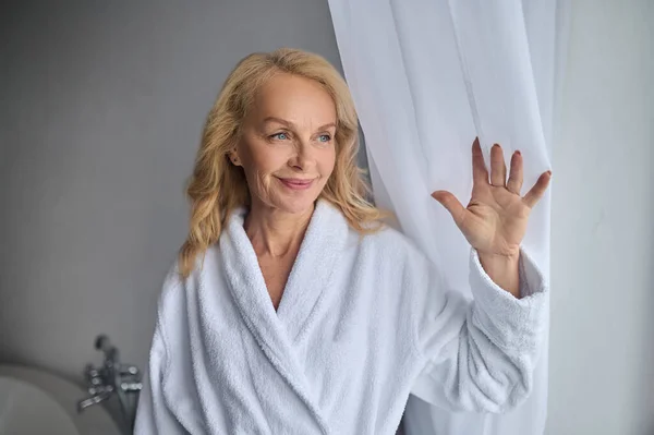 Блондинка середнього віку жінка в білому халаті відчуває розслаблений — стокове фото