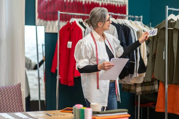 Femme debout regardant sur l'étiquette de prix sur chemisier — Photo