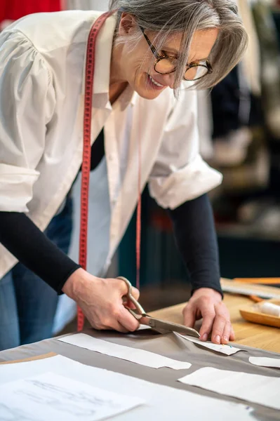 Веселая женщина вырезает узоры ножницами — стоковое фото