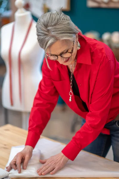 Vrouw netjes inpakken kleding op tafel — Stockfoto