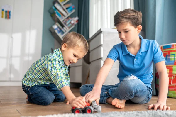 Двоє дітей грають зі своїми іграшковими машинами — стокове фото