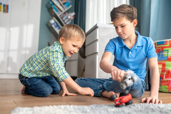 Focused elder brother entertaining his younger sibling — Stock Photo, Image