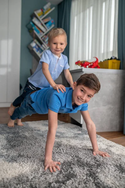Joyous kind uit te werken met zijn kleine broer — Stockfoto