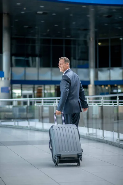 Вид ззаду ходячого чоловіка з валізою — стокове фото