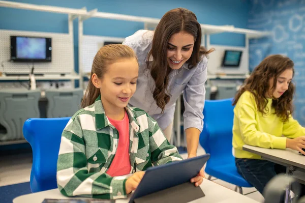 Mulher olhando para tablet de menina feliz — Fotografia de Stock