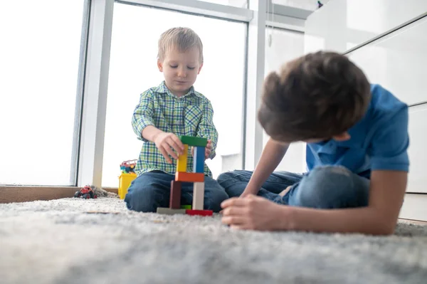 Deux garçons jouant avec des blocs de jouets dans une pièce — Photo