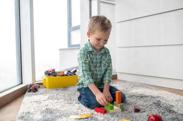 Calm focused child playing with the construction set — Stock Photo, Image