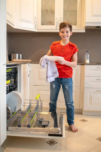 台所用タオルで洗濯板を拭く楽しい少年 — ストック写真