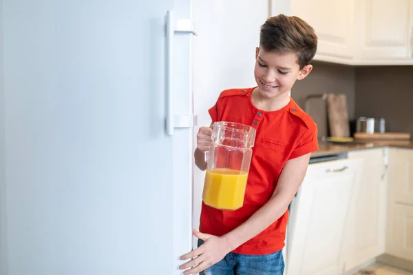 Sorrindo menino satisfeito fechando a porta do frigorífico — Fotografia de Stock