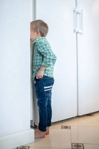 Mały chłopiec bawi się w chowanego w domu — Zdjęcie stockowe