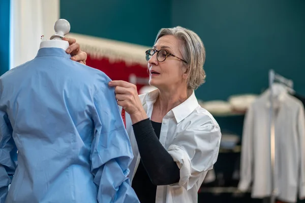 Vrouw aanraken blouse staan in de buurt van dummy — Stockfoto