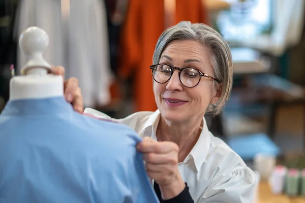 Vrouw met maatregel aanraken mannequin schouder — Stockfoto