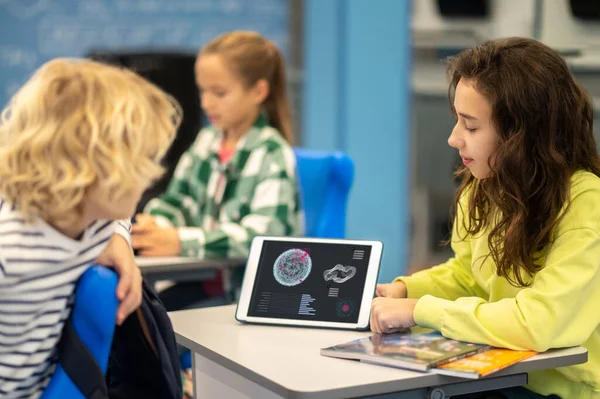 Chica mostrando pantalla de la tableta con información educativa para chico —  Fotos de Stock