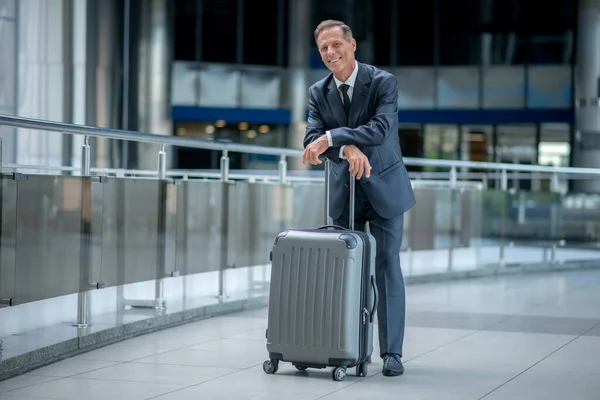 Muž s kufrem stojící v terminálu — Stock fotografie