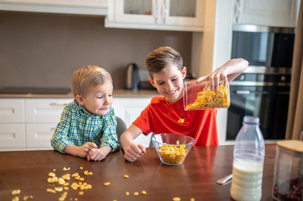 Kid assistindo seu irmão fazendo café da manhã na cozinha — Fotografia de Stock