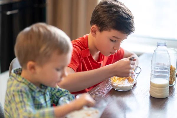 Zwei Kinder verzehren Haferflocken während des morgendlichen Essens — Stockfoto